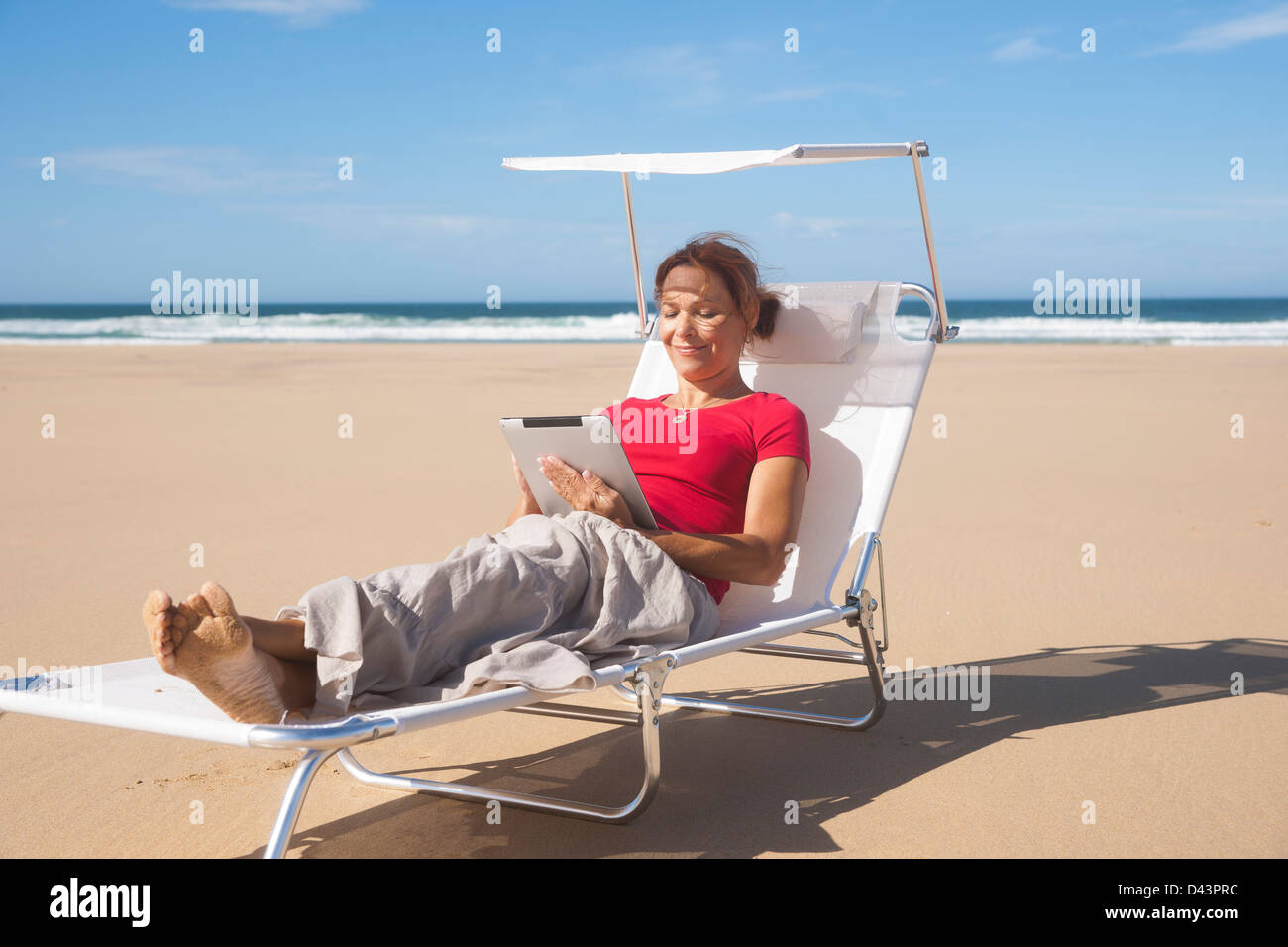 Woman Using Tablet at the Beach, Camaret-sur-Mer, Crozon Peninsula, Finistere, Brittany, France Stock Photo