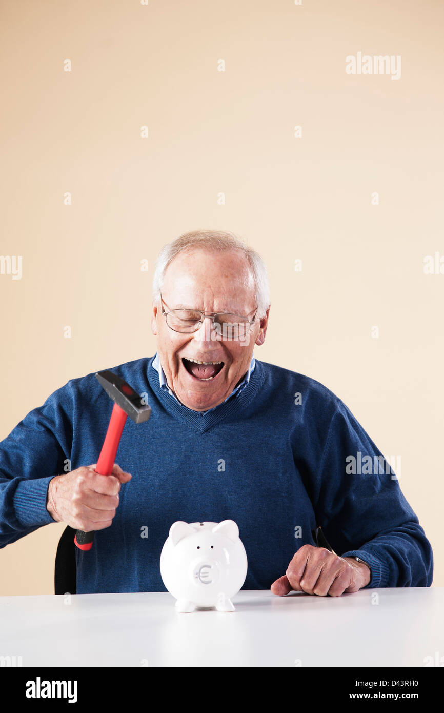 Portrait of Senior Man Breaking Piggy Bank Stock Photo - Alamy