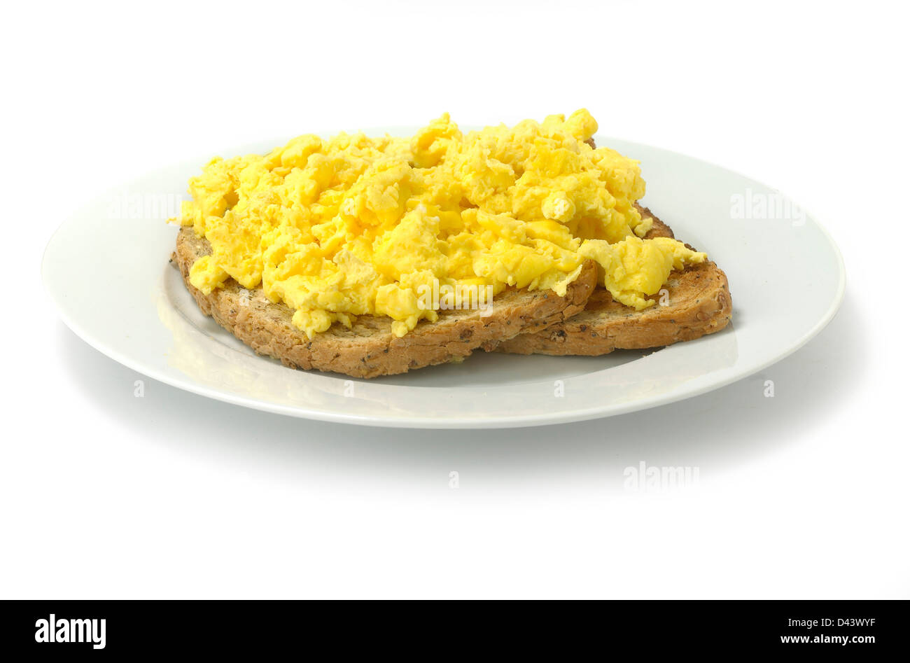Scrambled eggs on two pieces of toast cut out white background Stock