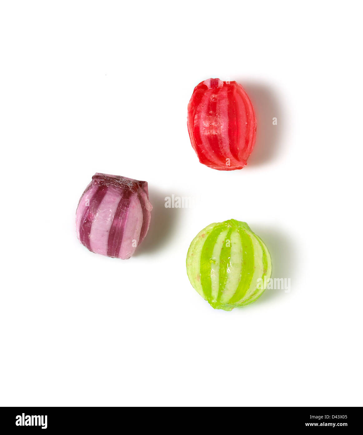 Three colourful boiled sweets cut out white background Stock Photo