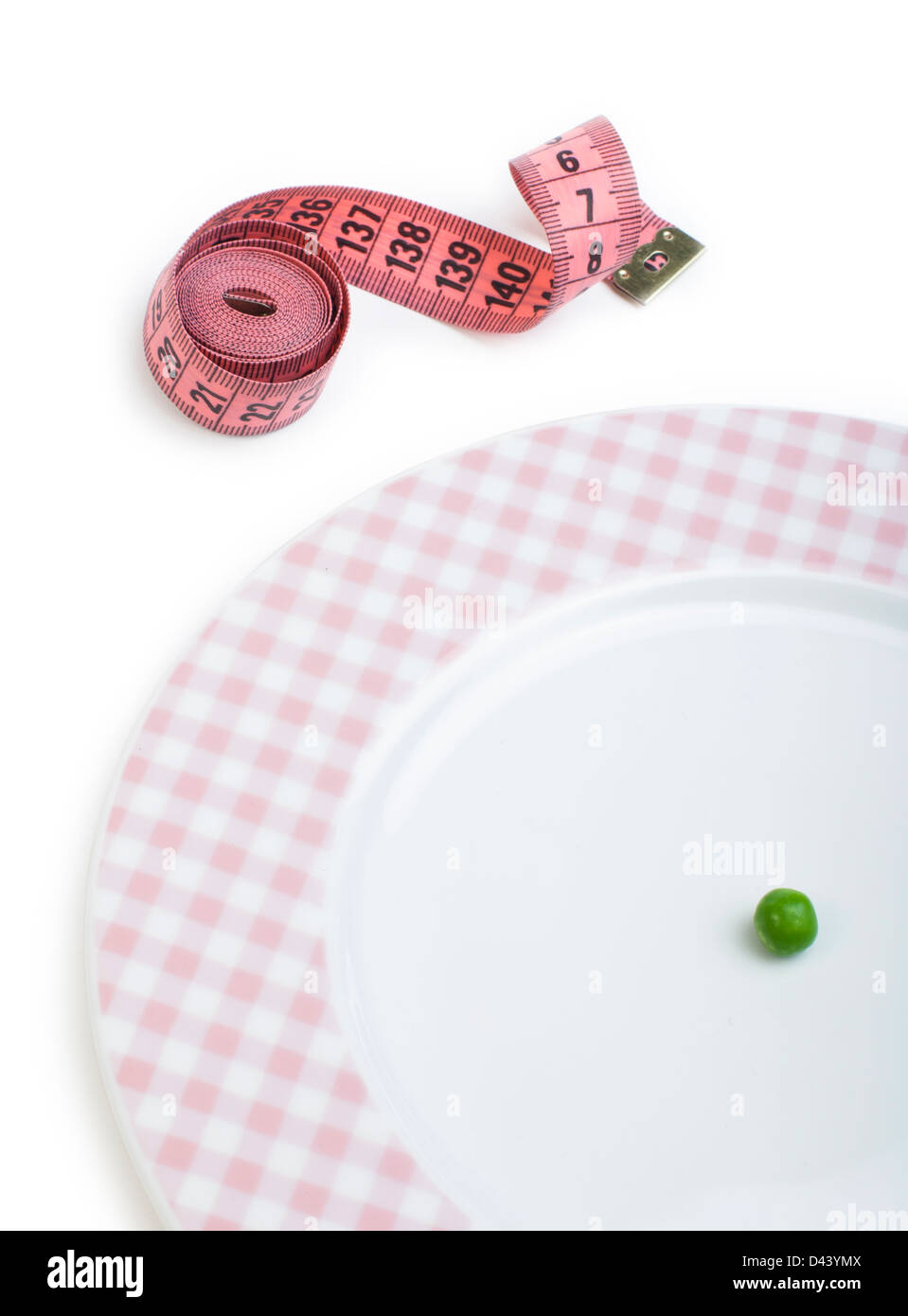 Plate with one peas. Dumbbell and centimeter measure. Studio shot Stock Photo