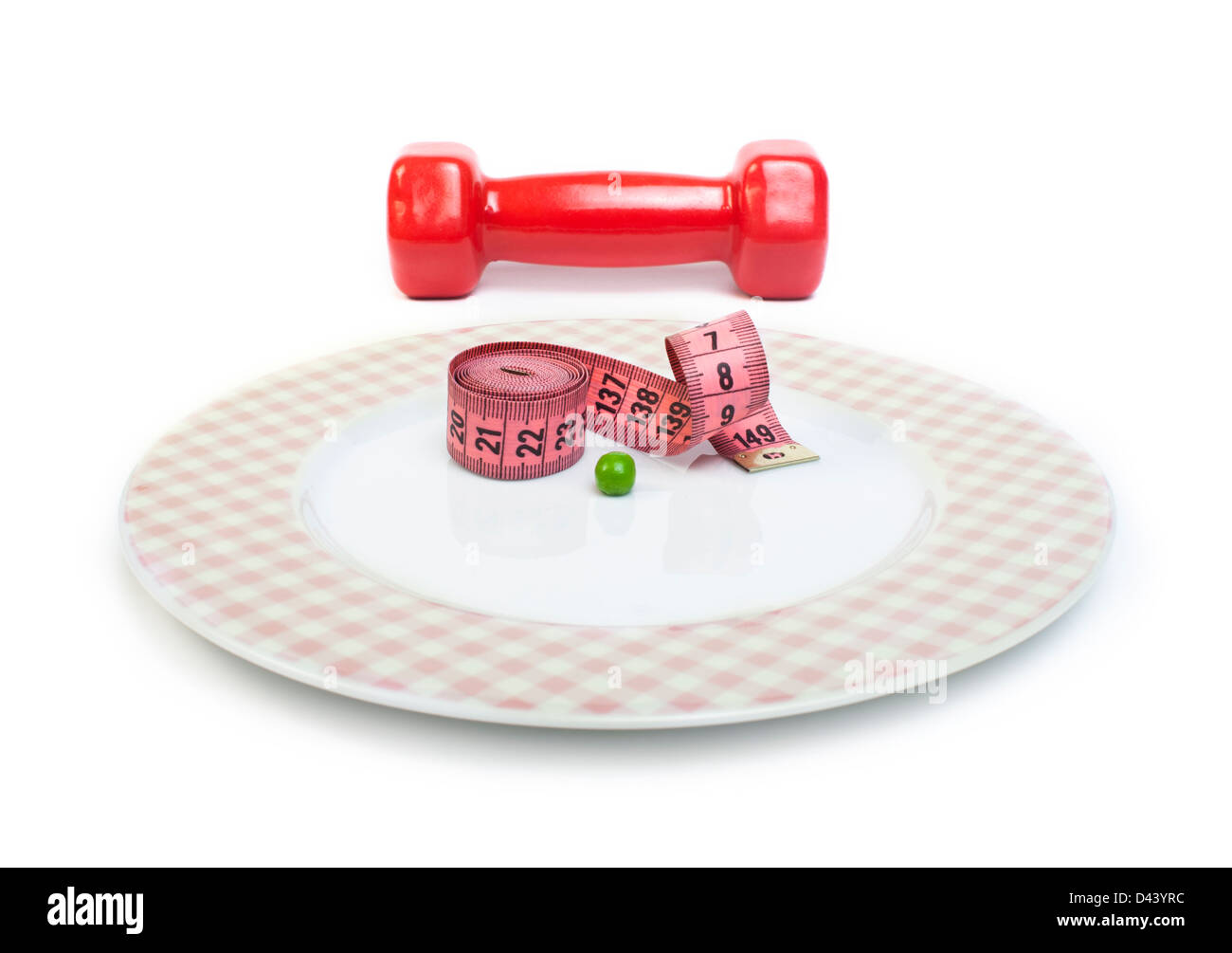 Plate with one peas. Dumbbell and centimeter measure. Studio shot Stock Photo