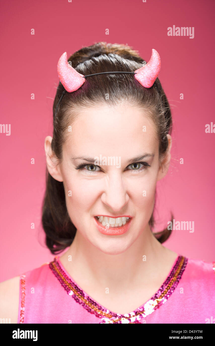 Portrait of Woman Wearing Devil Horns and Making Faces Stock Photo