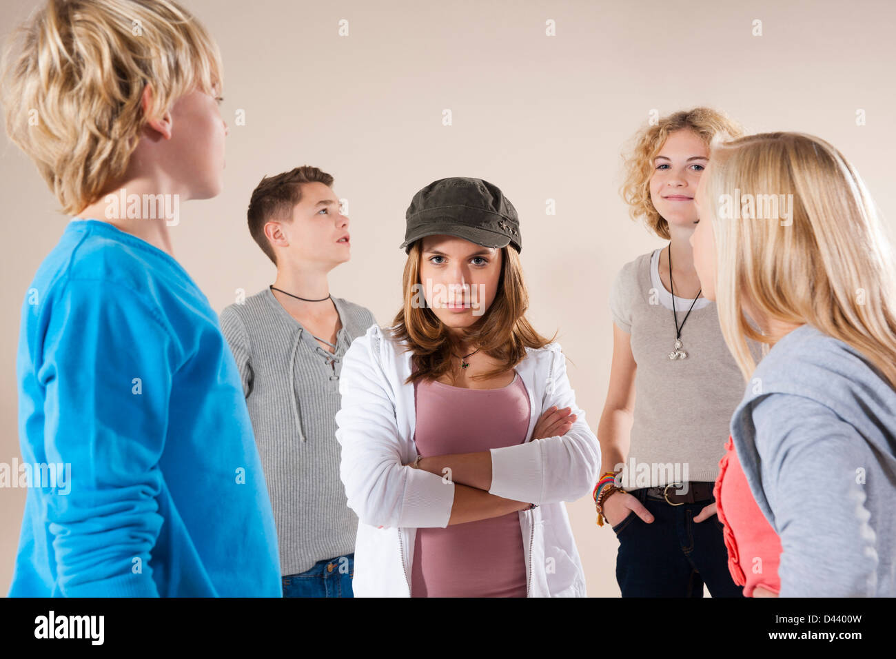Portrait of Teenage Girl wearing Baseball Hat Looking at Camera, Standing in the Middle of Group of Teenage Boys and Grils Stock Photo