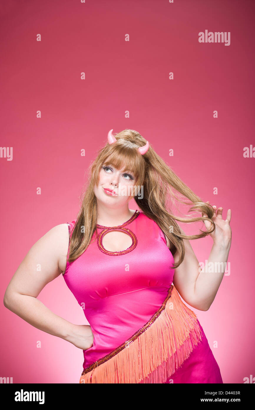 Portrait of woman dressed as a devil, with devil horns having fun and goofing around Stock Photo