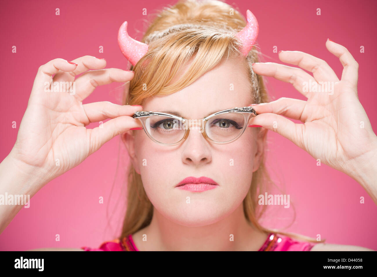 Portrait of Woman Wearing Devil Horns and Vintage Eyeglasses Stock
