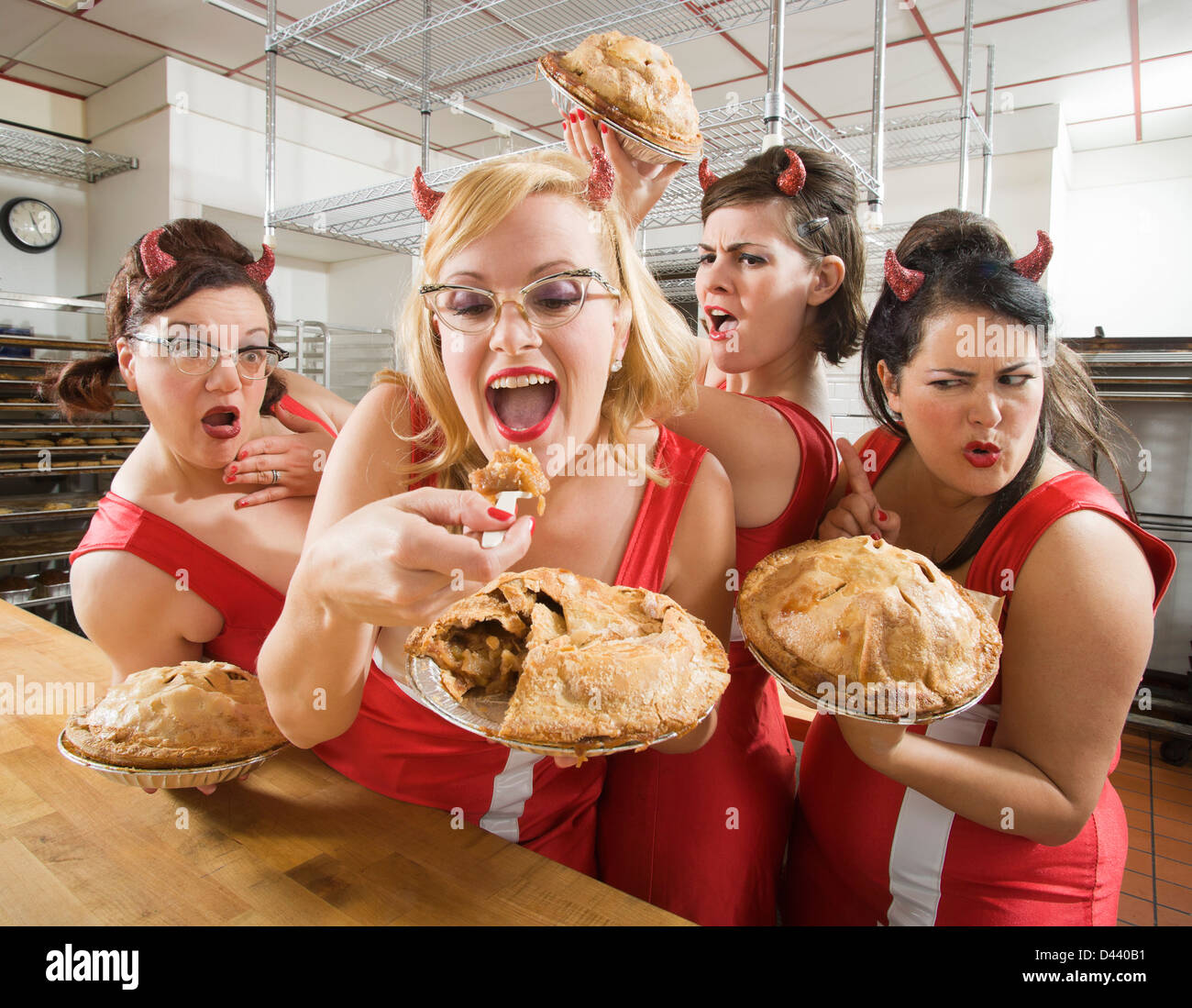 Women Wearing Devil Horns at a Bakery, Oakland, Alameda County, California, USA Stock Photo