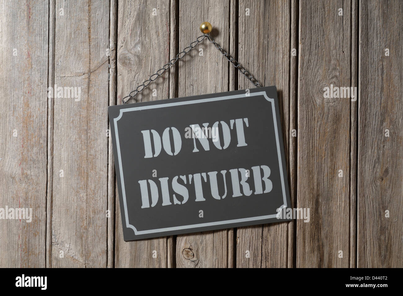 Do Not Disturb Sign Hanging on Wooden Wall Stock Photo