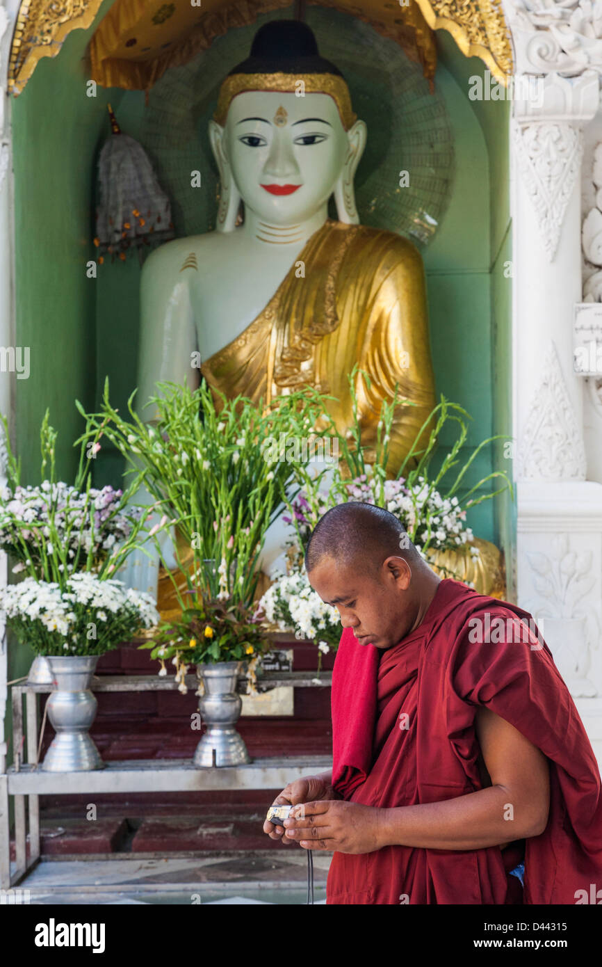 Myanmar, Yangon, Shwedagon Pagoda, Monk with Camera Stock Photo