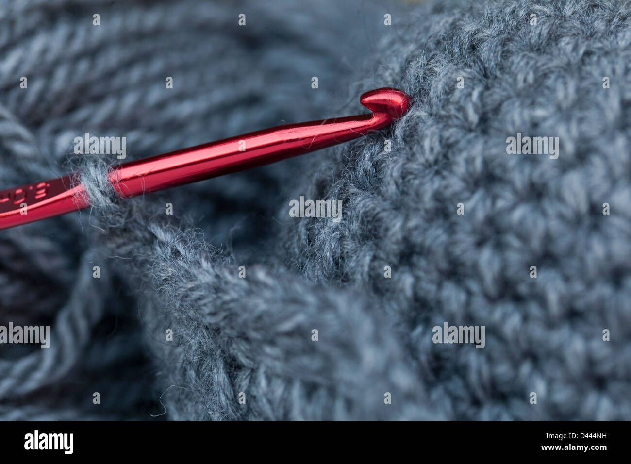 Red crochet hook in a grey skein Stock Photo
