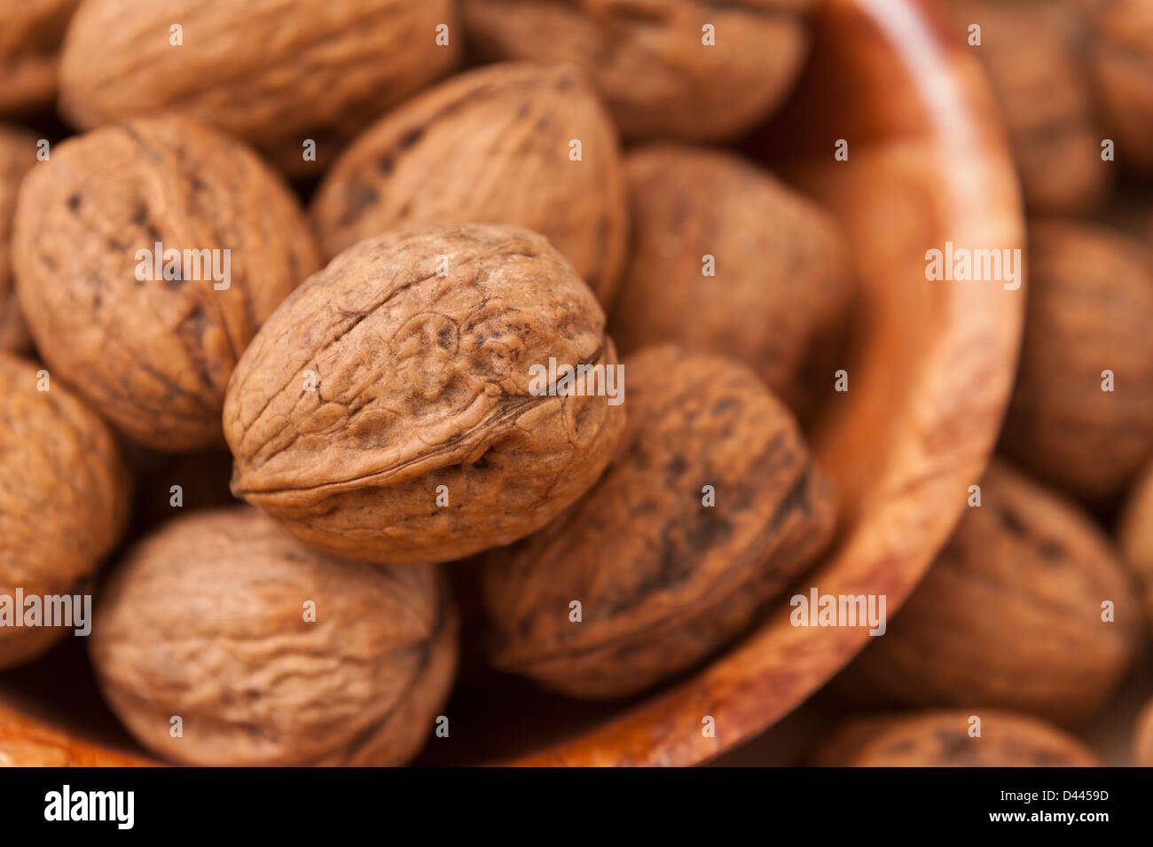 Walnuts in a wooden dish / bowl - selective focus Stock Photo