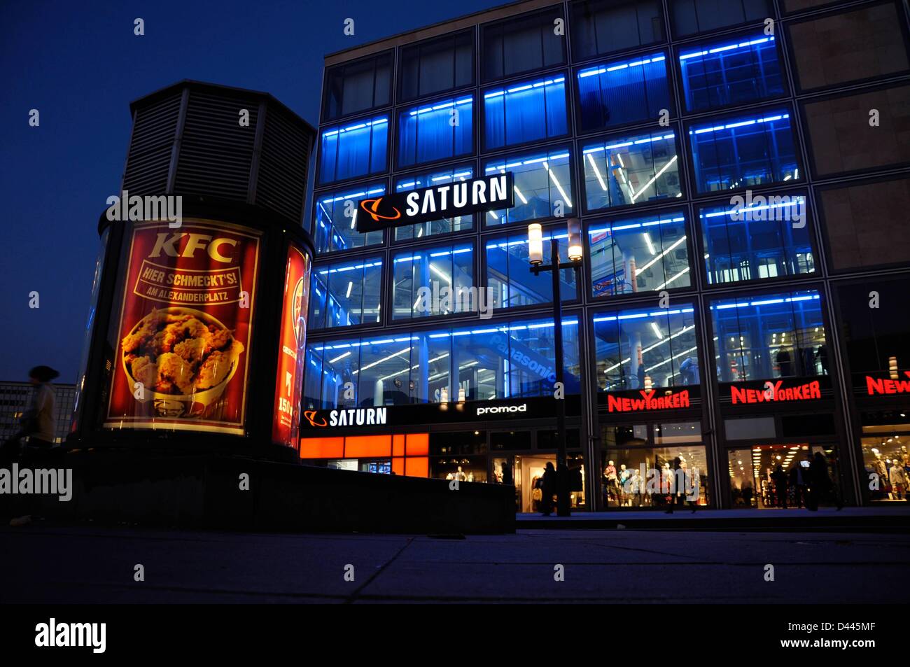 An advertising column is pictured in front of a branch of the consumer electronics retailer Saturn at Alexanderplatz in Berlin, Germany, 7 March 2011. A poster advertises the fast food chain 'Kentucky Fried Chicken', which also has a joint at Alexanderplatz. Fotoarchiv für ZeitgeschichteS.Steinach Stock Photo