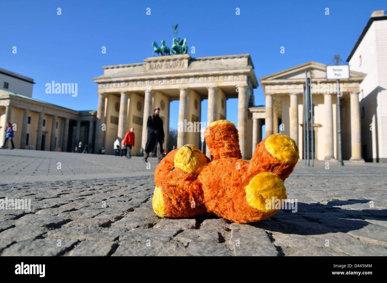 Illustration - A teddy bear is pictured lying on the ground in front of the Brandenburg Gate in Berlin, Germany, 6 March 2011. Fotoarchiv für ZeitgeschichteS.Steinach Stock Photo