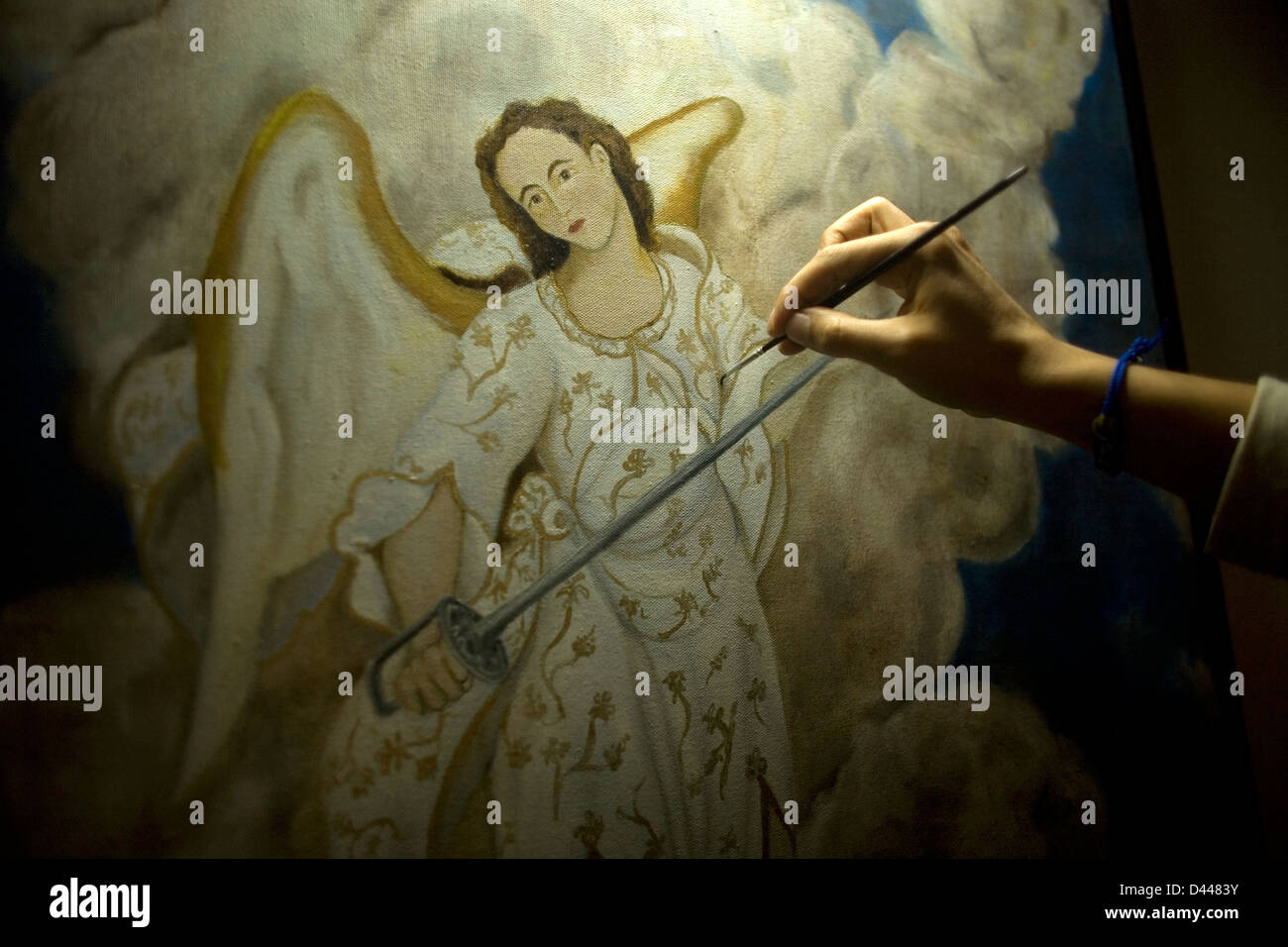An artist paints Saint Michael, the Archangel, in Casa de los Frailes hotel in Oaxaca, Mexico. Stock Photo