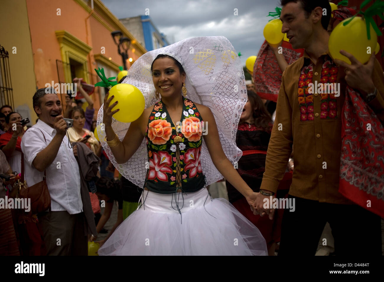 A bride dressed as a Tehuana holds her groom by the hand during a wedding in Oaxaca, Mexico. Stock Photo