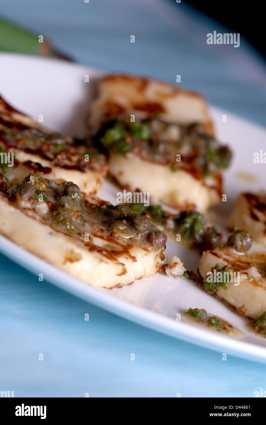 Pieces of Halloumi cheese with lime and caper dressing Stock Photo
