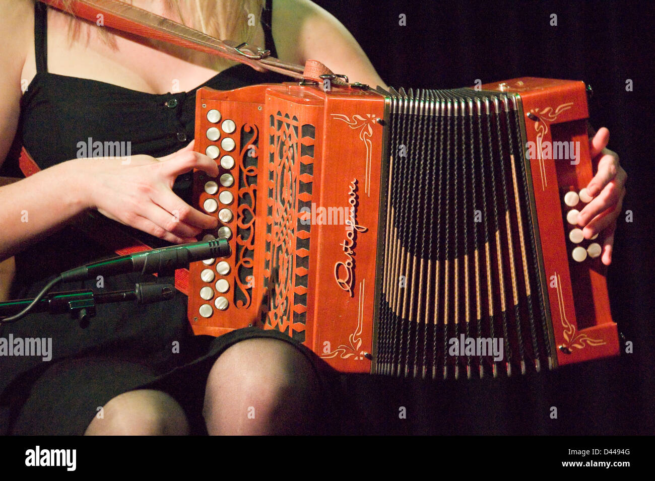Horizontal close up of a traditional Irish accordionist playing on stage. Stock Photo