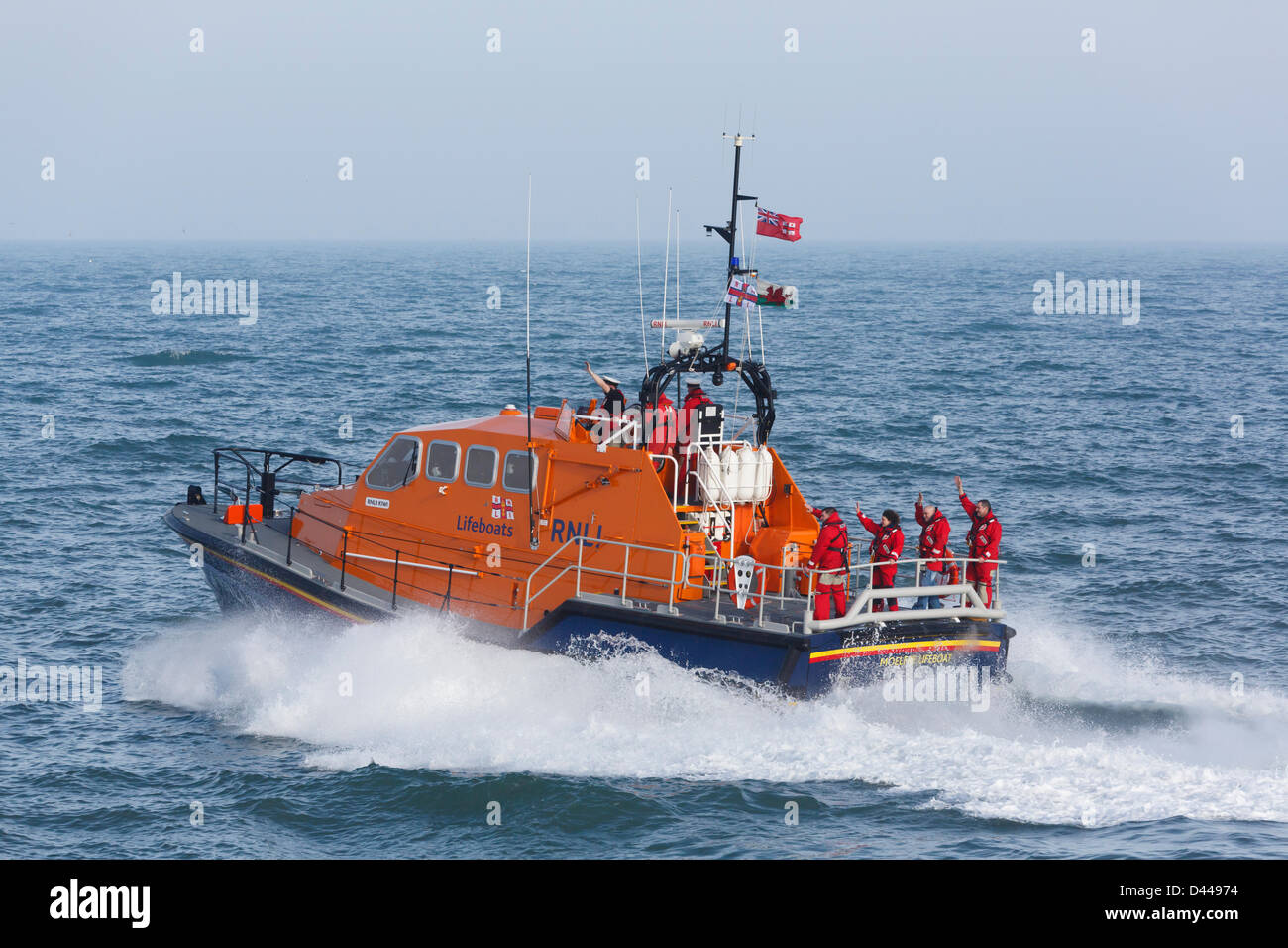 Moelfre, Isle of Anglesey, Wales, UK, Mon 4th March 2013. RNLI lifeboat crew wave to the welcoming crowd from the new £2.7 million Tamar class vessel 'Kiwi' funded by the bequest of a New Zealand seaman Reginald James Clark. The bigger and safer boat replaces the Tyne class vessel which has been in service since 1988. Stock Photo