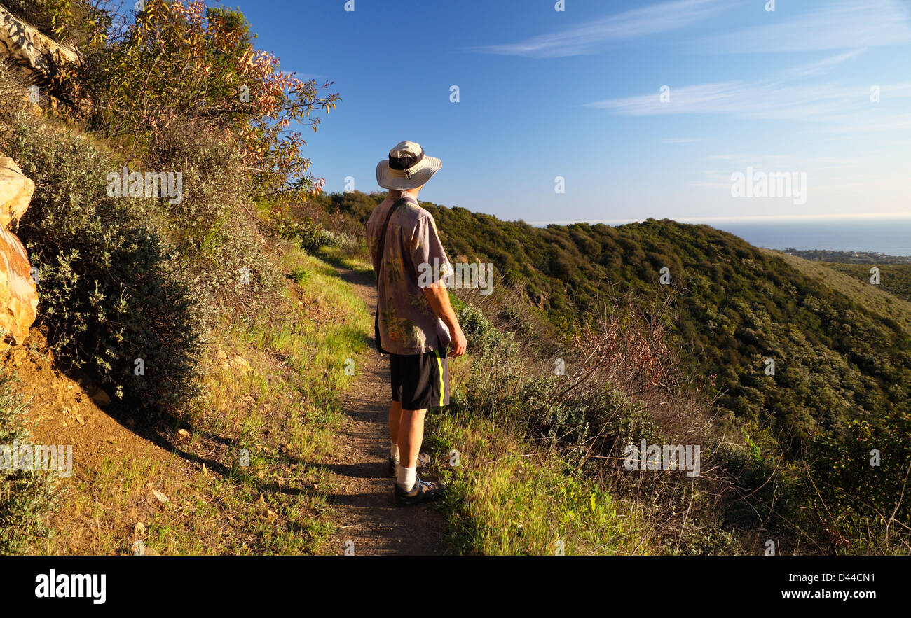Hiker sees ocean beyond Zuma Canyon along the Canyon View Trail at Zuma Canyon in Malibu, California Stock Photo