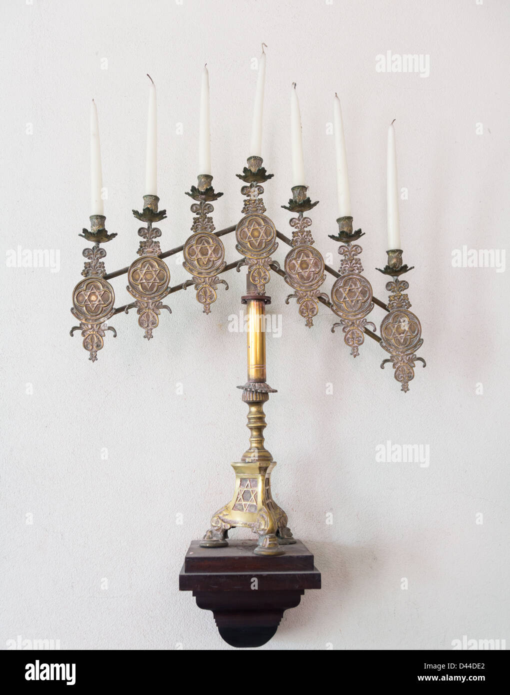 Antique ornate menorah in brass with old tallow candles Stock Photo