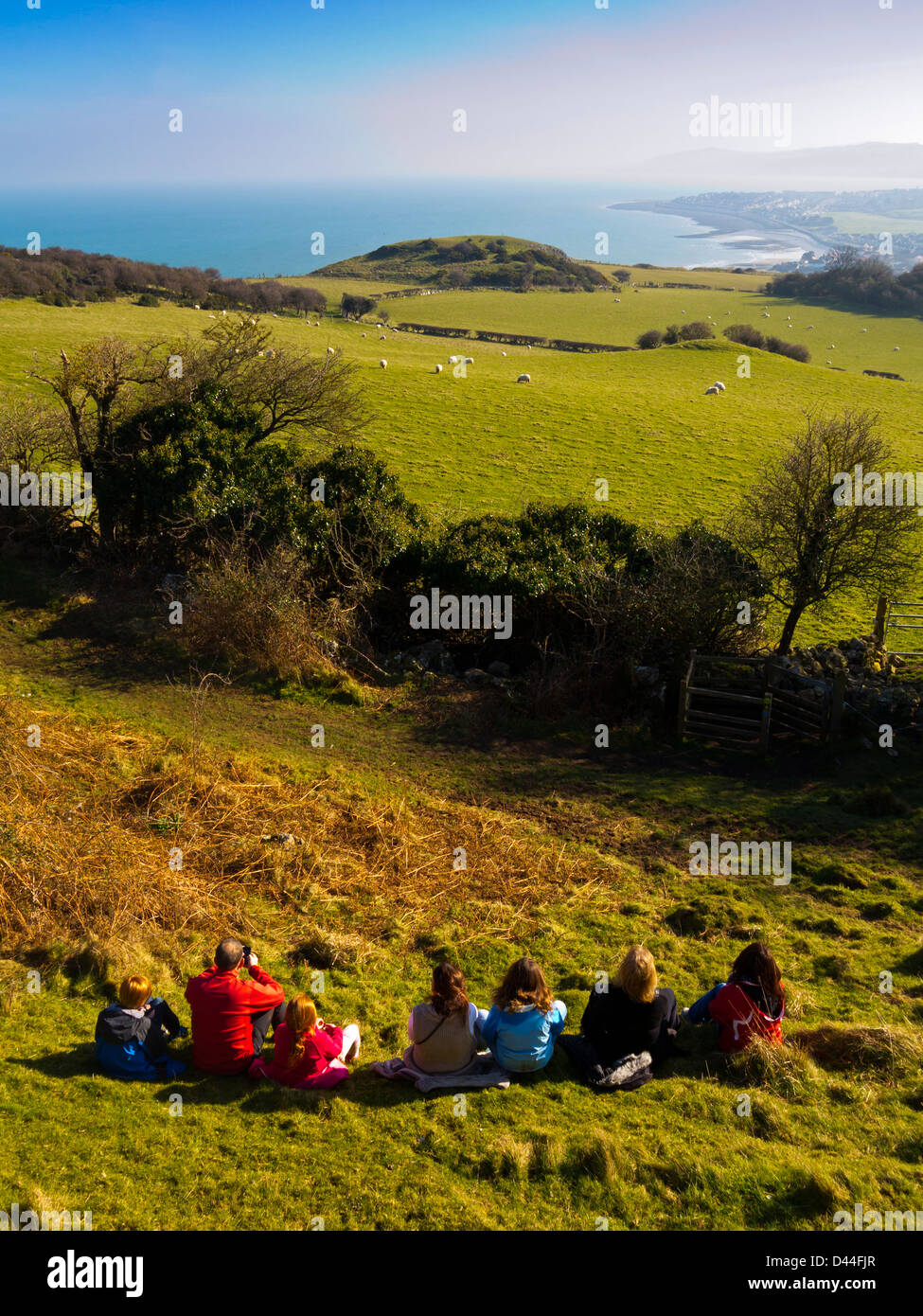 Group of walkers resting and enjoying the view from the Little Orme near Llandudno towards Colwyn Bay Conwy North Wales UK Stock Photo