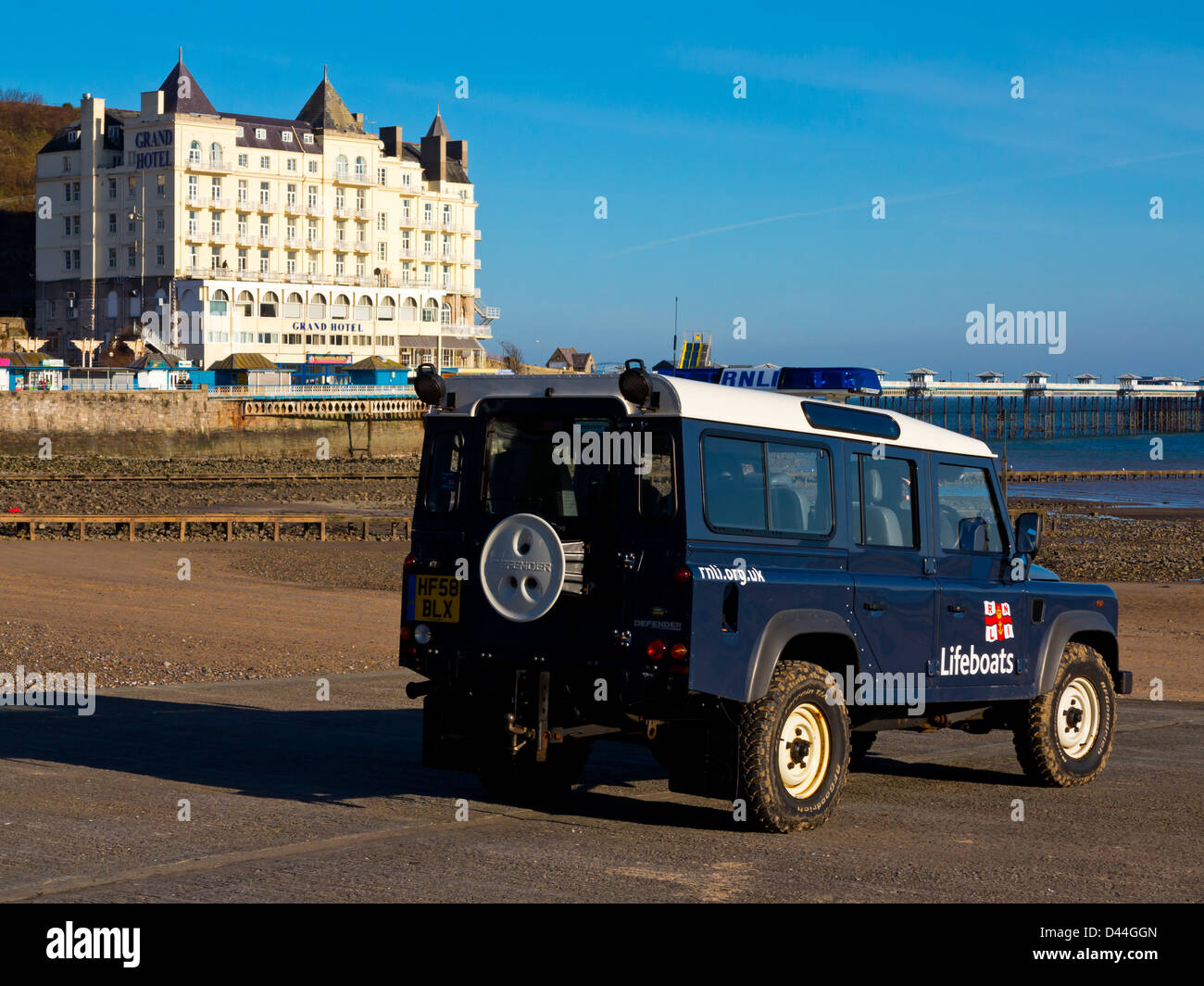 RNLI lifeboat support Land Rover parked on the North Shore beach Llandudno North Wales UK with the Grand Hotel in background Stock Photo