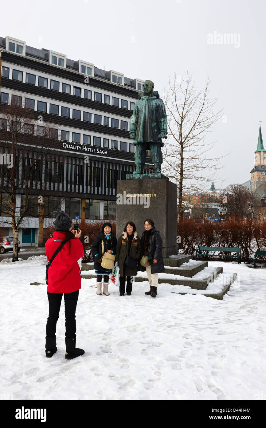 female asian tourists taking photos in front of Roald Amundsen statue