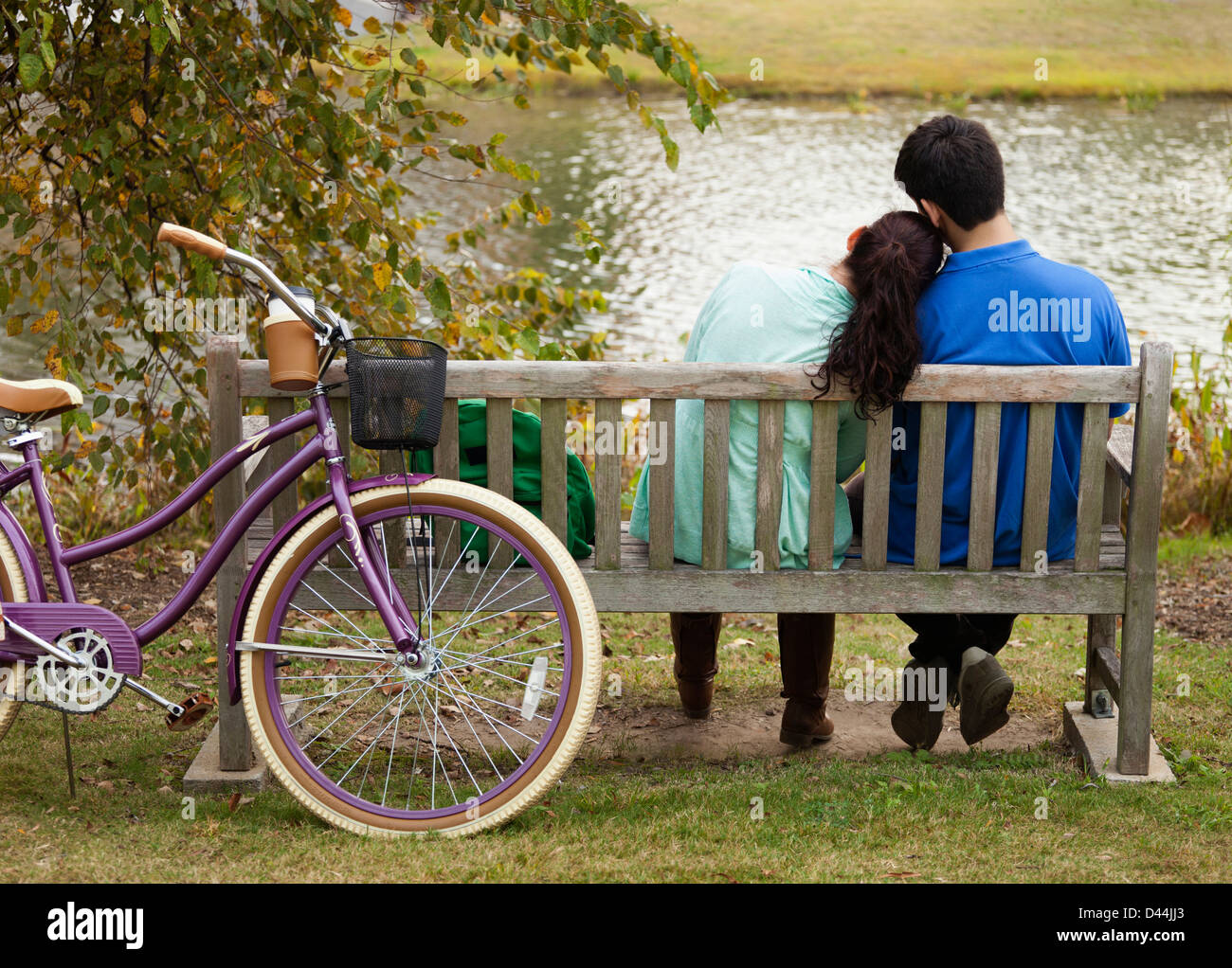 Student couple sitting on park bench Stock Photo - Alamy