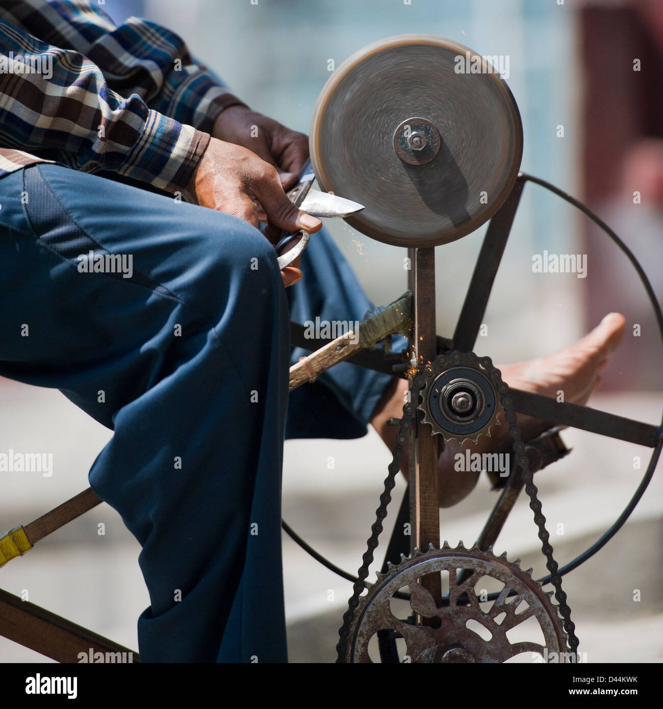 Man sharpening knives and scissors on the street in Nepal Stock Photo