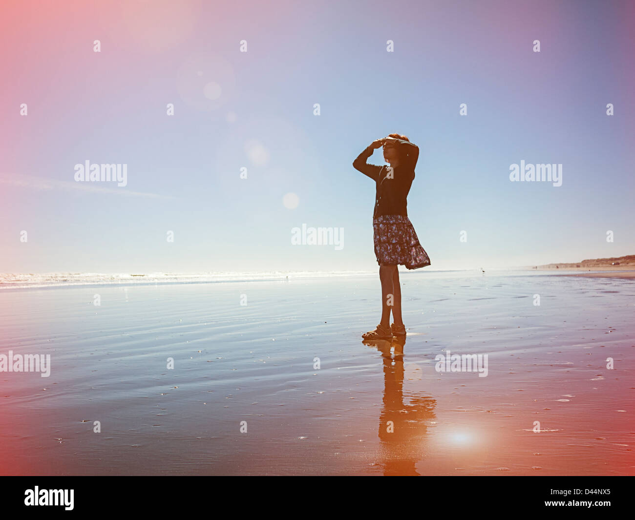 Light leaks, woman looks out to sea, New Zealand. Stock Photo