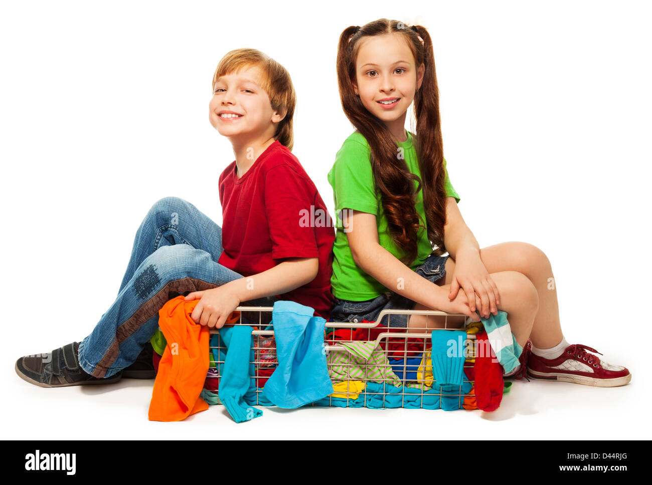 two eight years old kids in clothing basket isolated on white Stock Photo