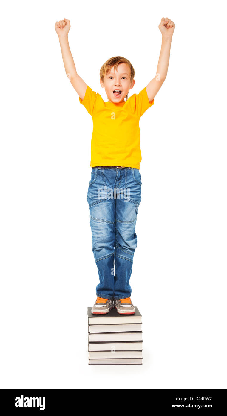 Cute boy standing on a pile of books and shouting Stock Photo - Alamy
