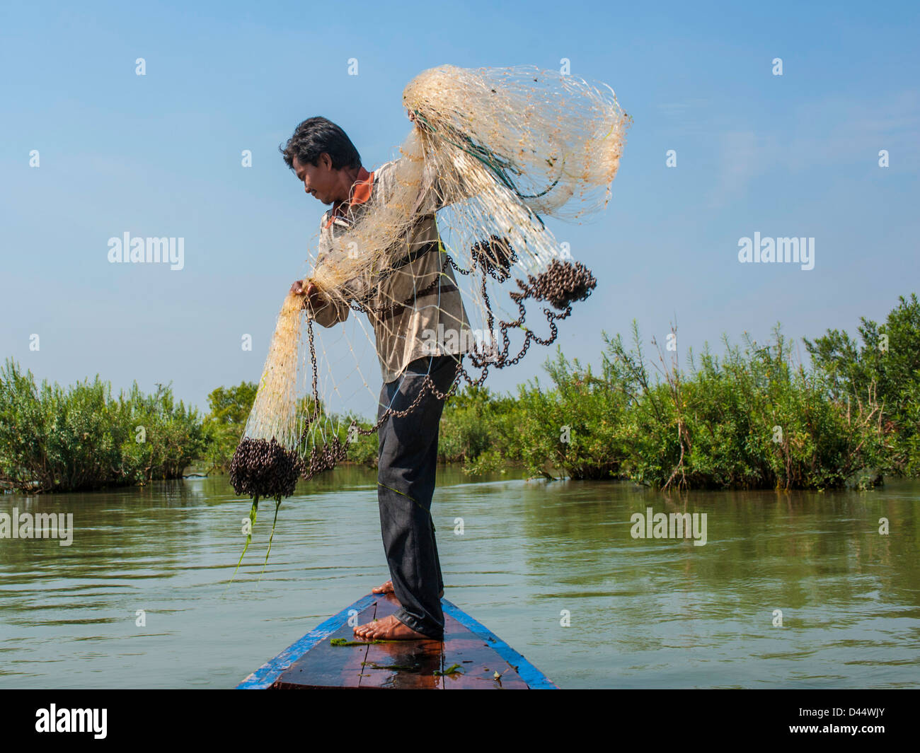 Man throwing fishing net into water hires stock photography and images