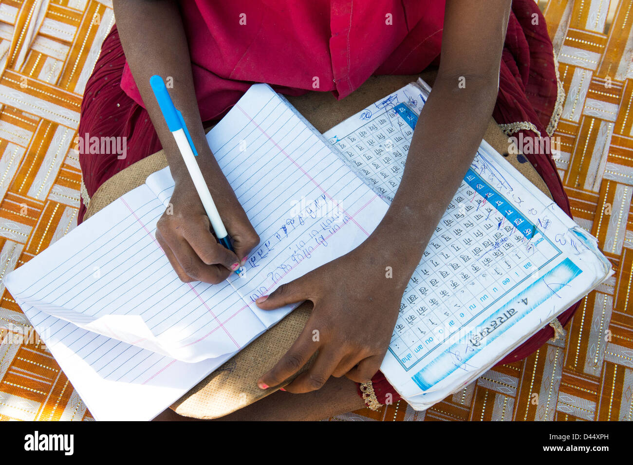 Indian village girl practicing writing Telegu in a school book for homework. Andhra Pradesh.India Stock Photo