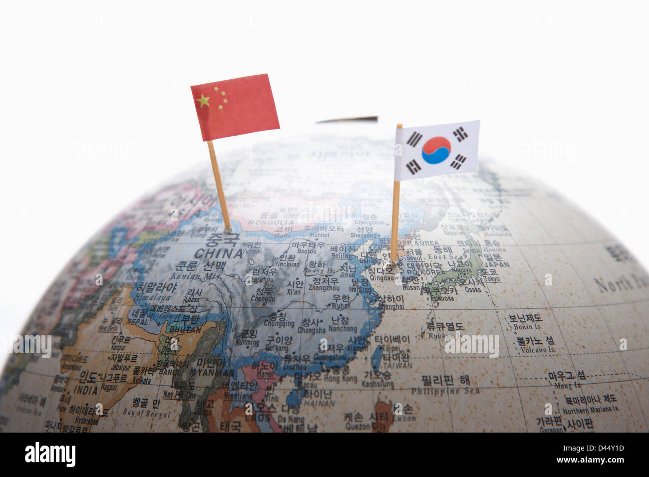 a Chinese flag and Korean flag on each part of a globe Stock Photo
