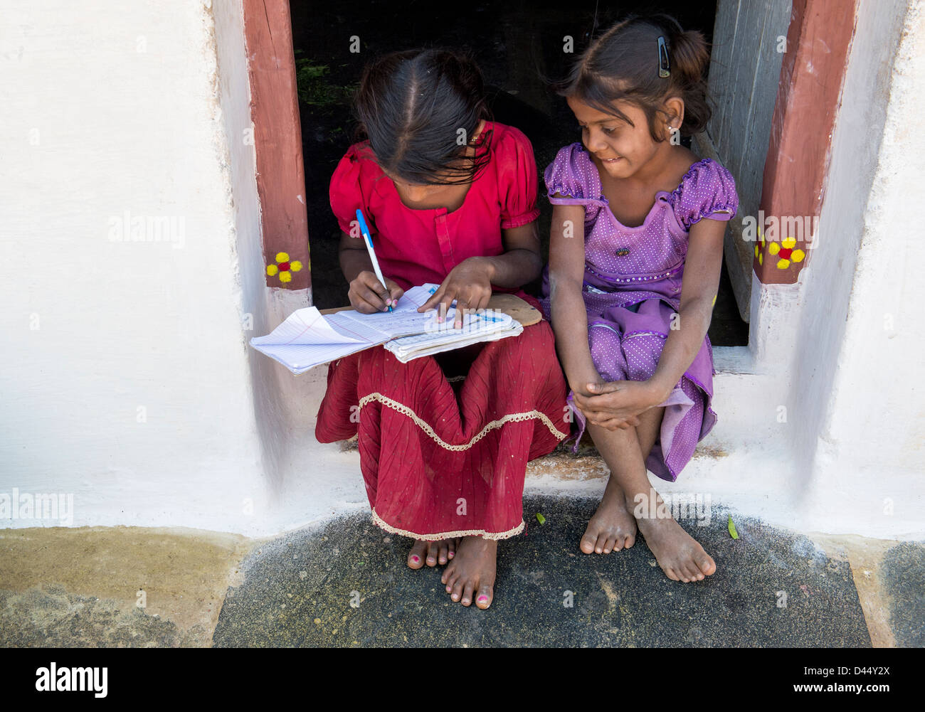 Indian village girls practicing writing Telegu in a school book for homework. Andhra Pradesh.India Stock Photo