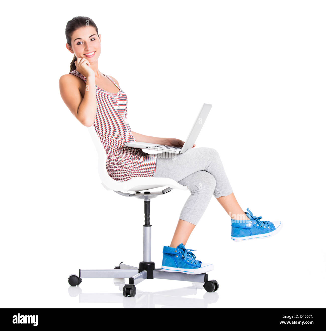 Beautiful student sitting in a chair with a laptop, isolated over a