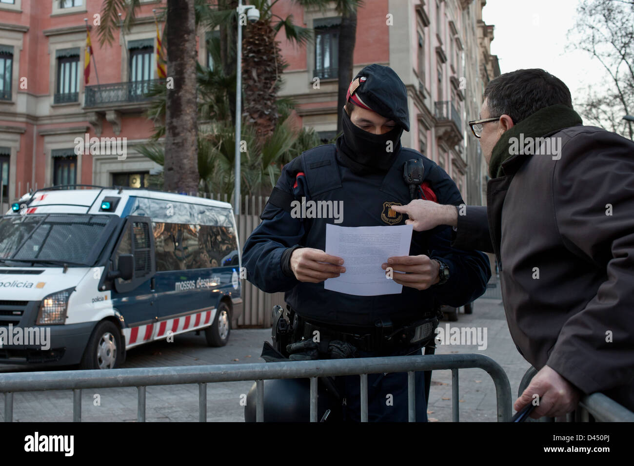 Manifestante entregando un documento de quejas a un mosso d'esquadra durante la manifestación del 23F en Barcelona Stock Photo