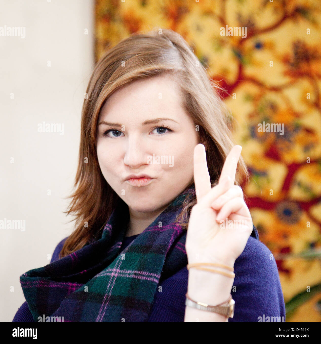 Attractive caucasian brunette young woman age 19-21 years, giving a V sign Stock Photo