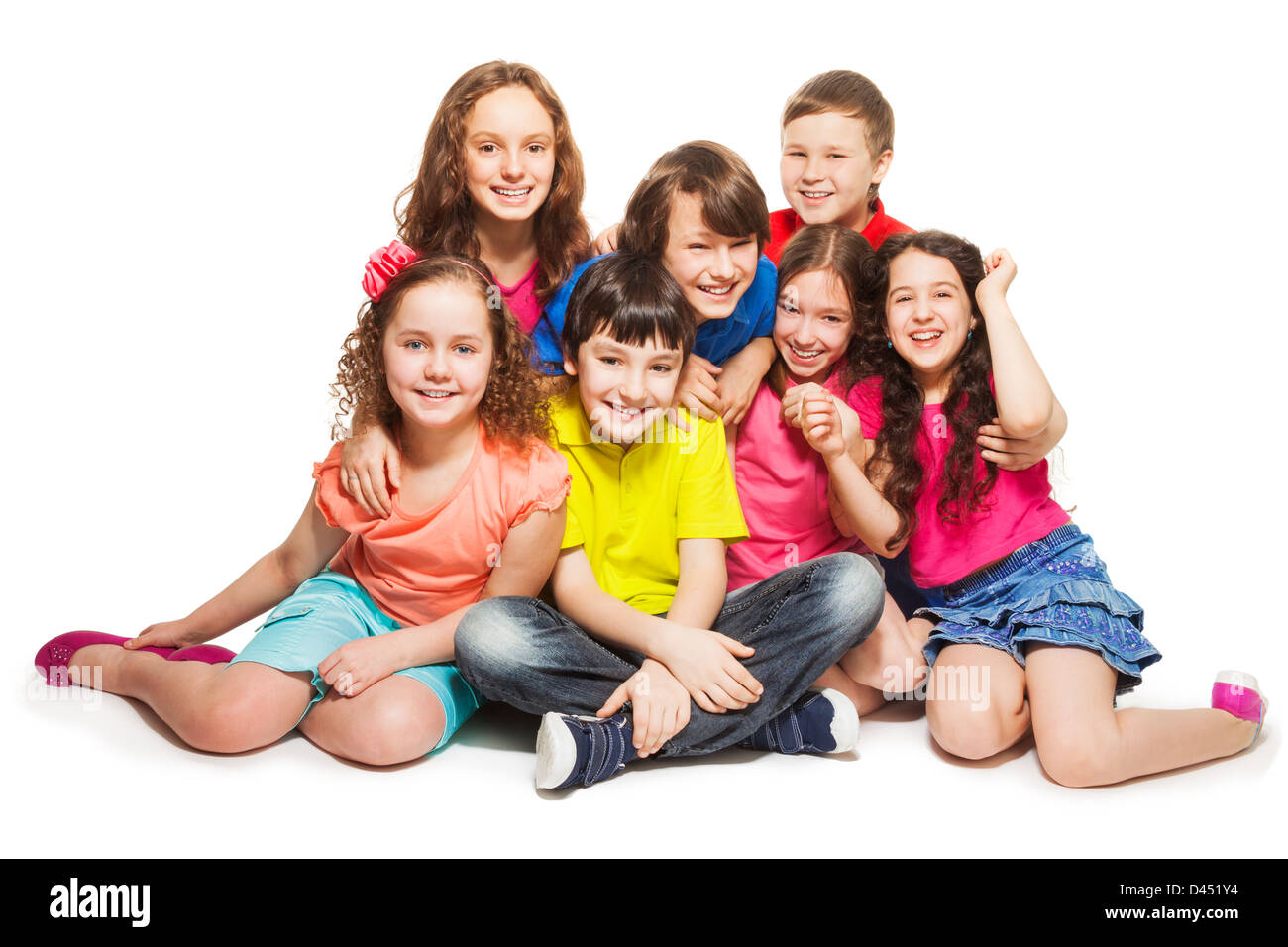 Group of happy kids sitting together hugging and smilng Stock Photo
