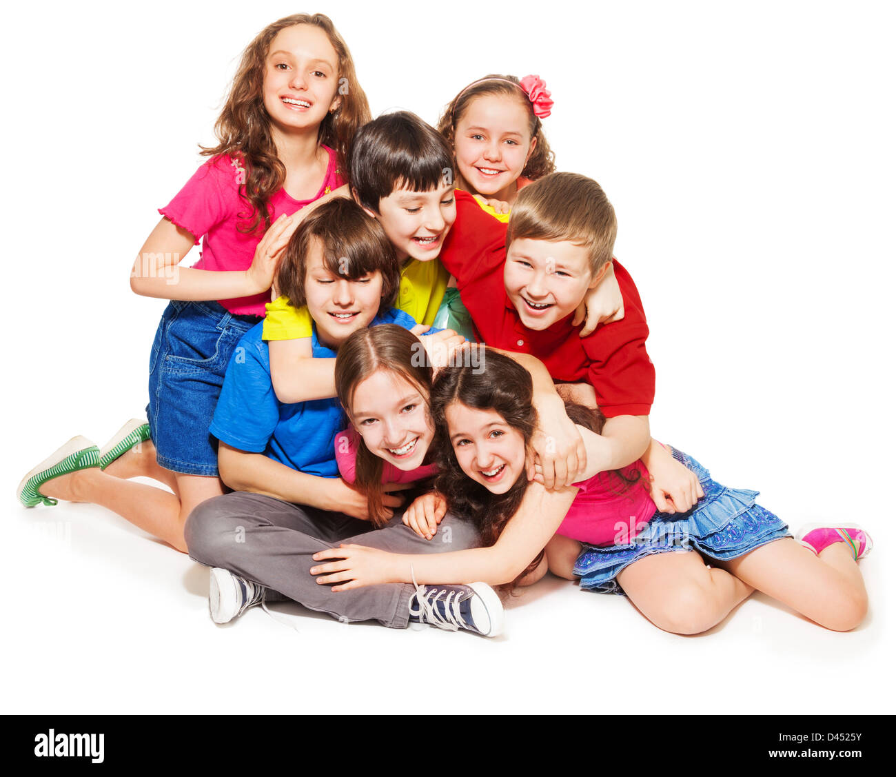 Group of happy kids - boys and girls sitting together, hugging, laughing Stock Photo