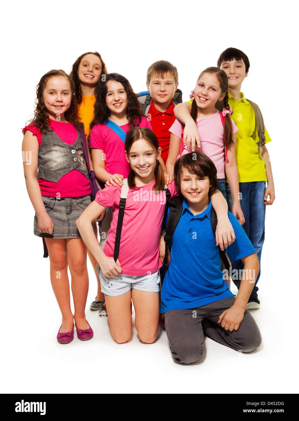 Group of 8 kids standing together with backpacks, smiling, laughing, on white Stock Photo