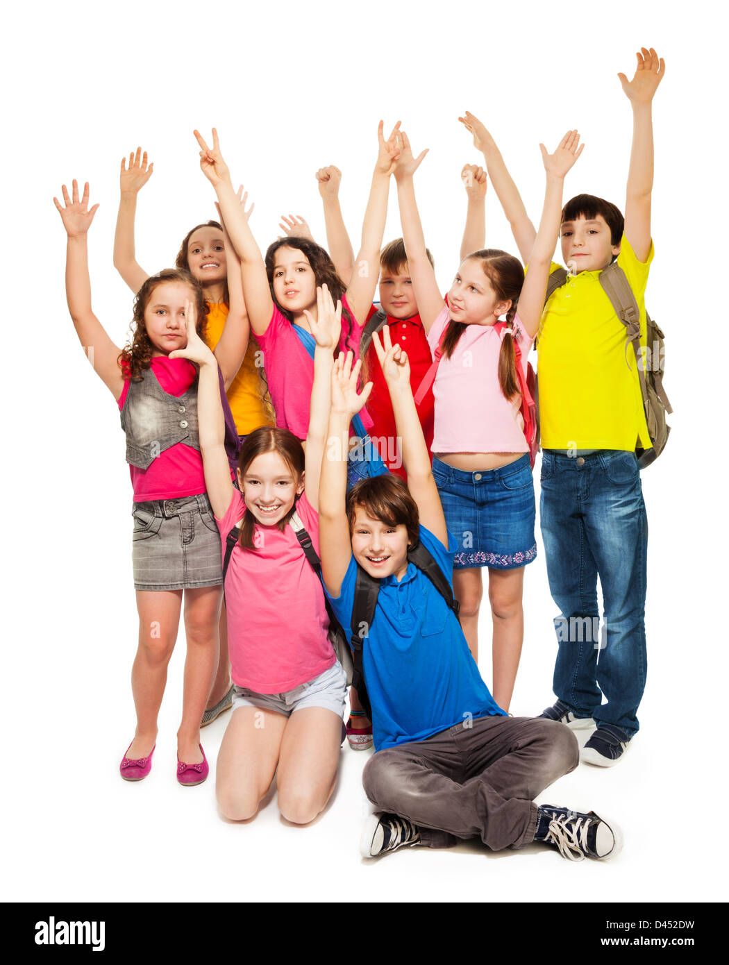 Group of happy kids, boys and girls lifting hands standing on white Stock Photo