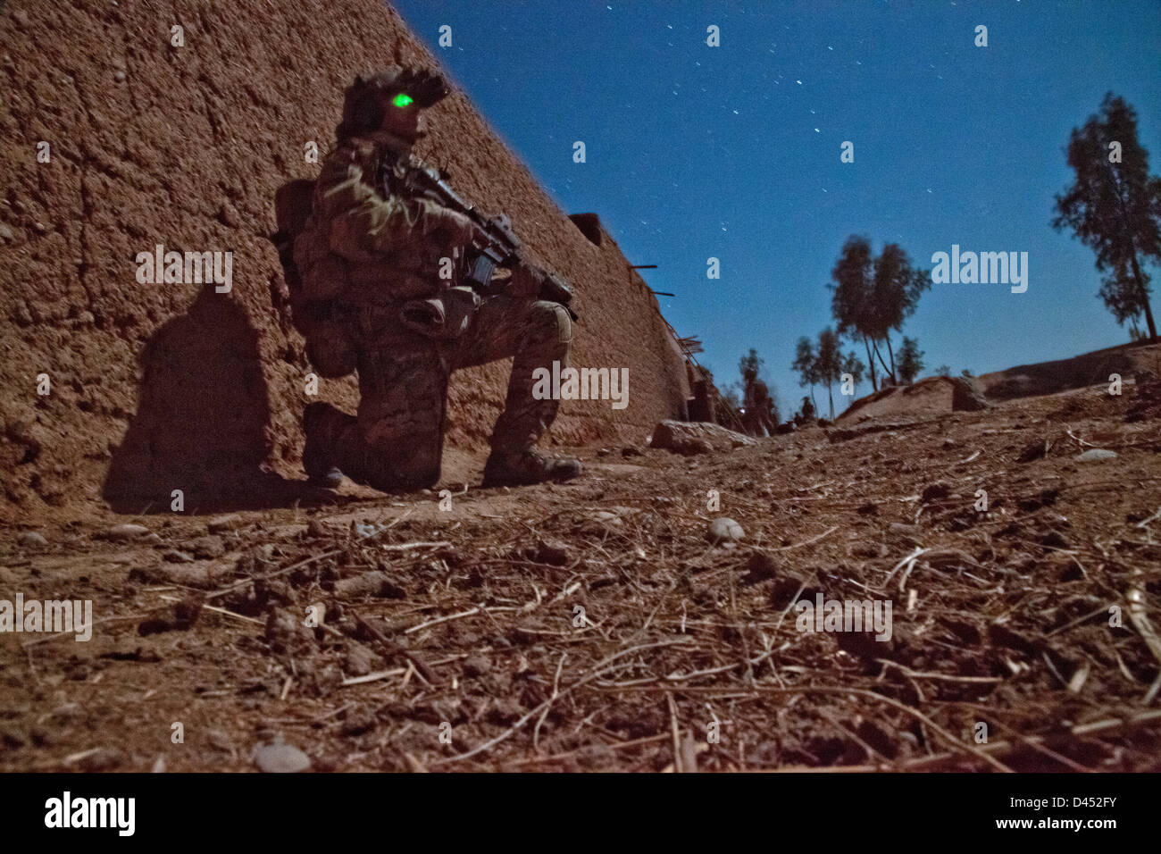 A US Marine shown in a time exposure during a night raid to arrest a presumed Taliban leader January 24, 2013 in Nawah-ye-Barakzai district, Helmand province, Afghanistan. Stock Photo