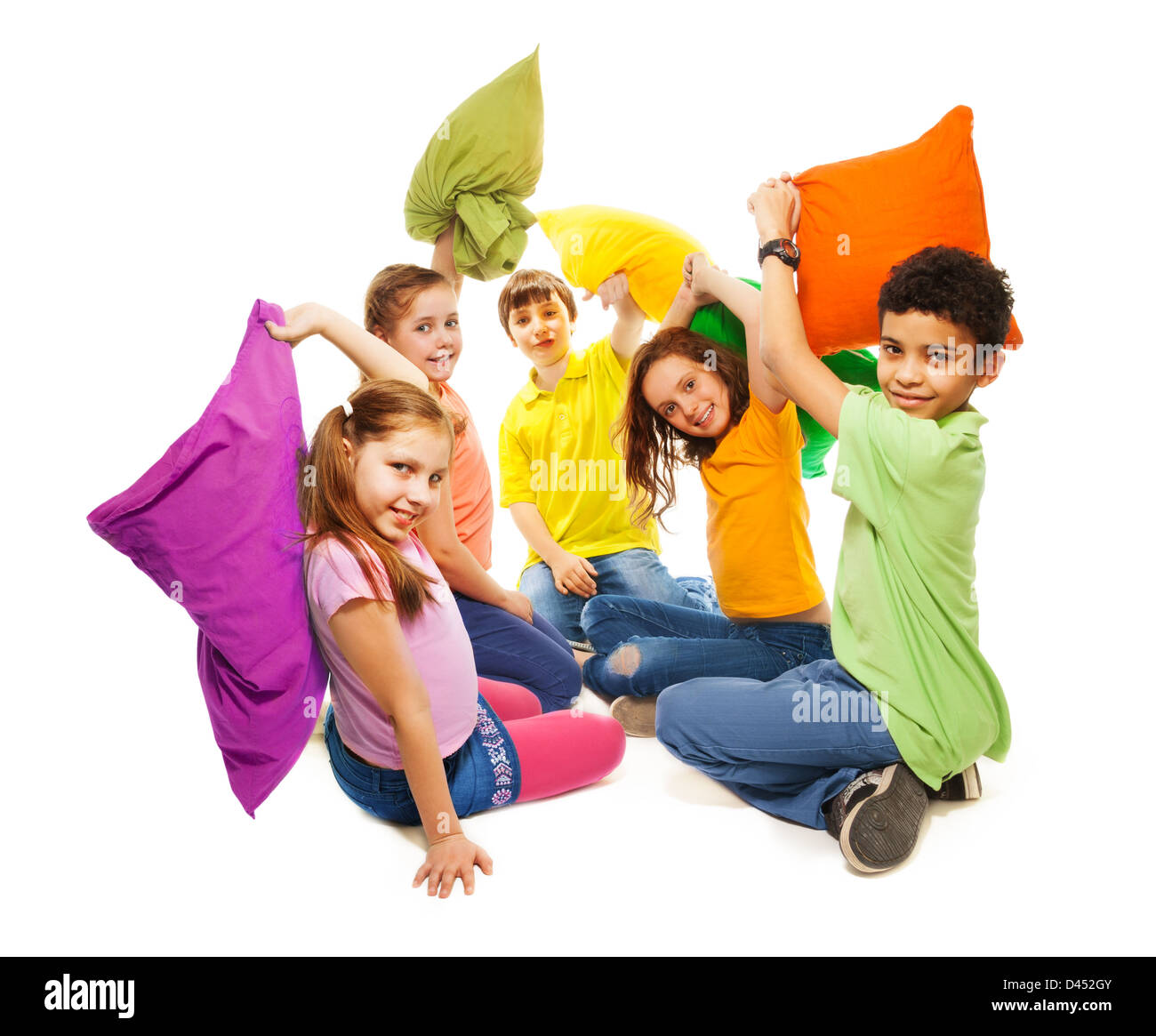Happy five teen kids, diversity looking, boys and girls fighting with pillows, laughing and having fun, isolated on white Stock Photo