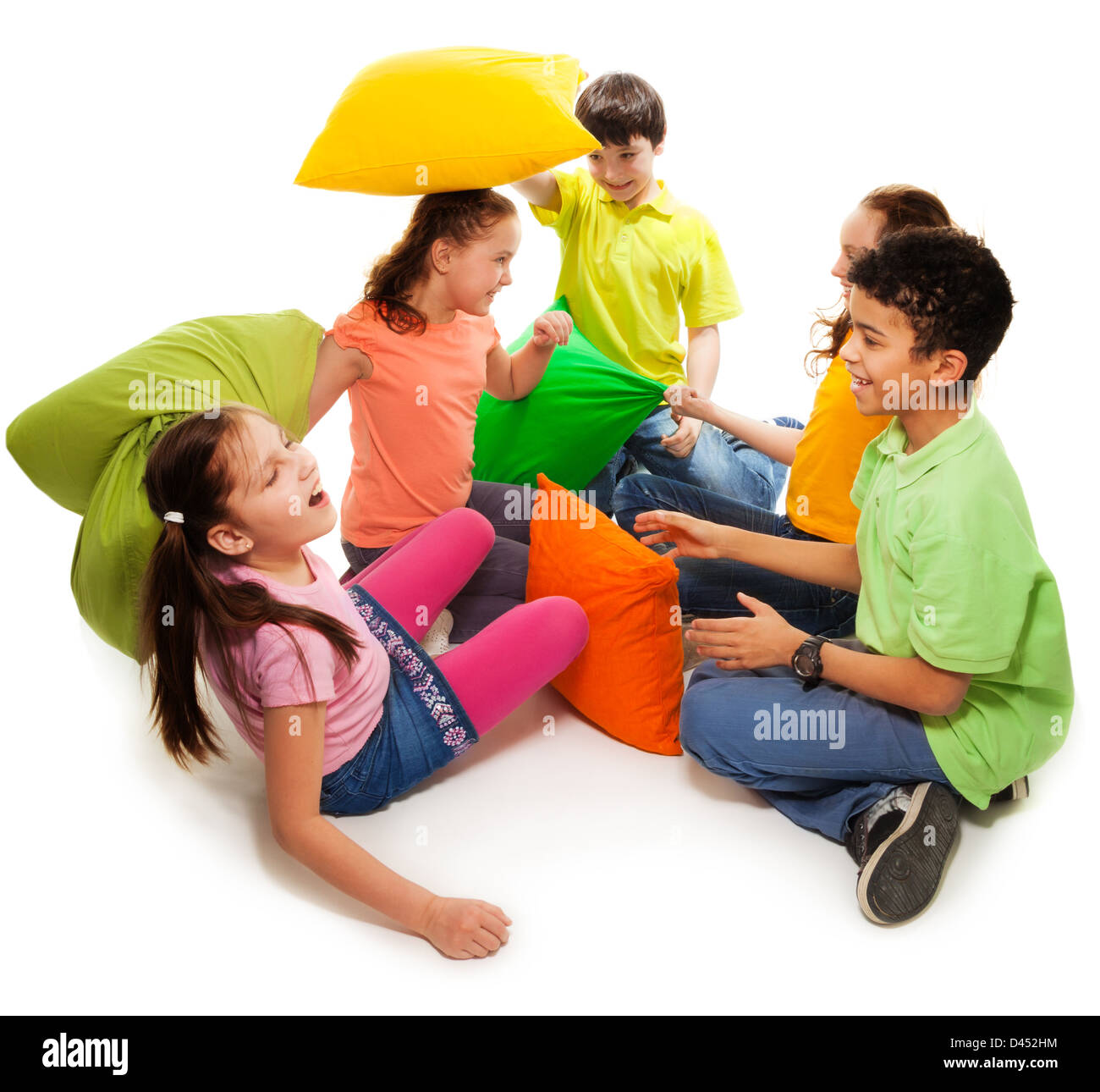 Five teen kids fighting with pillows, laughing and having fun, isolated on white Stock Photo