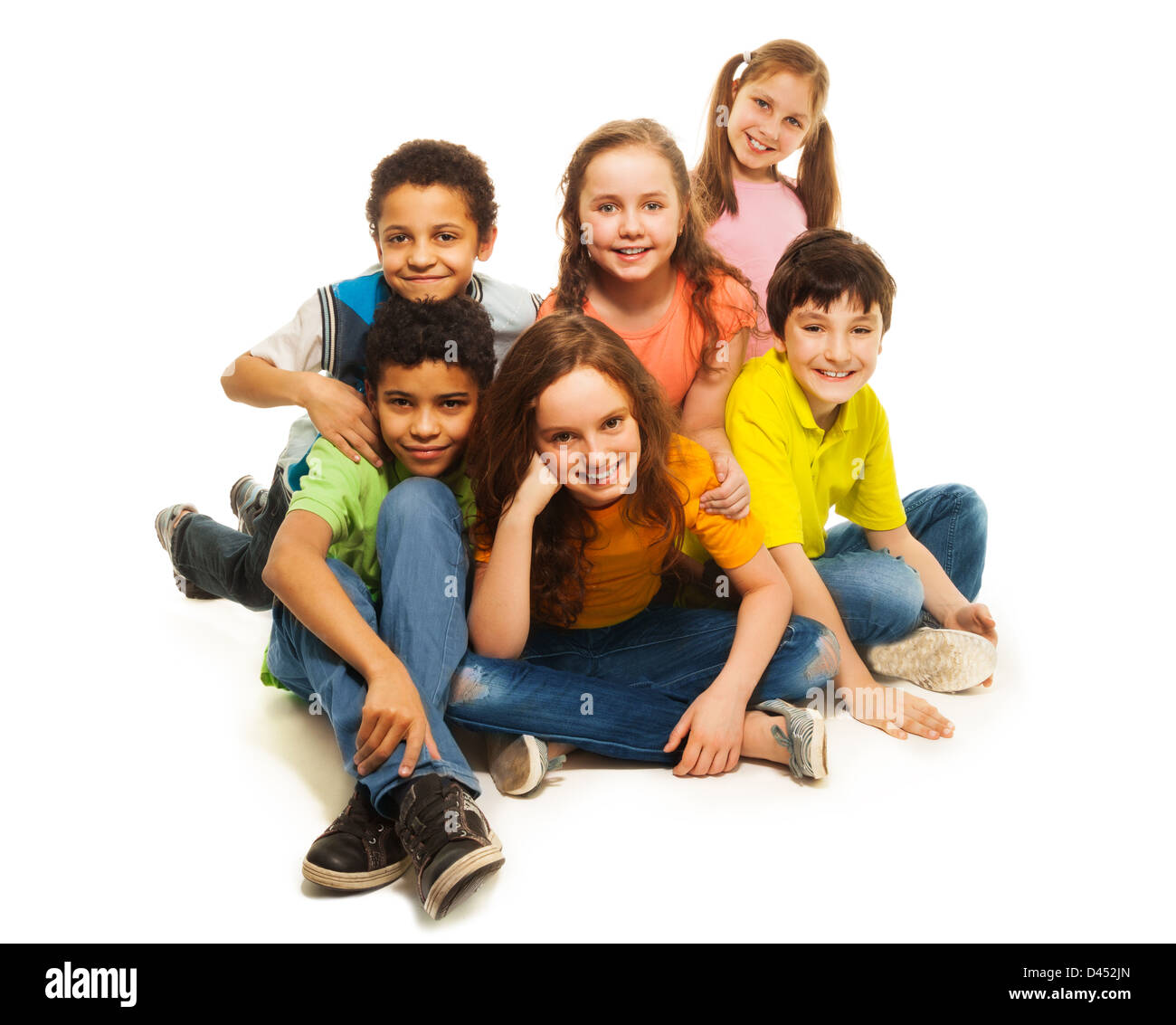 Group of black and Caucasian kids sitting happy together, smiling and laughing Stock Photo
