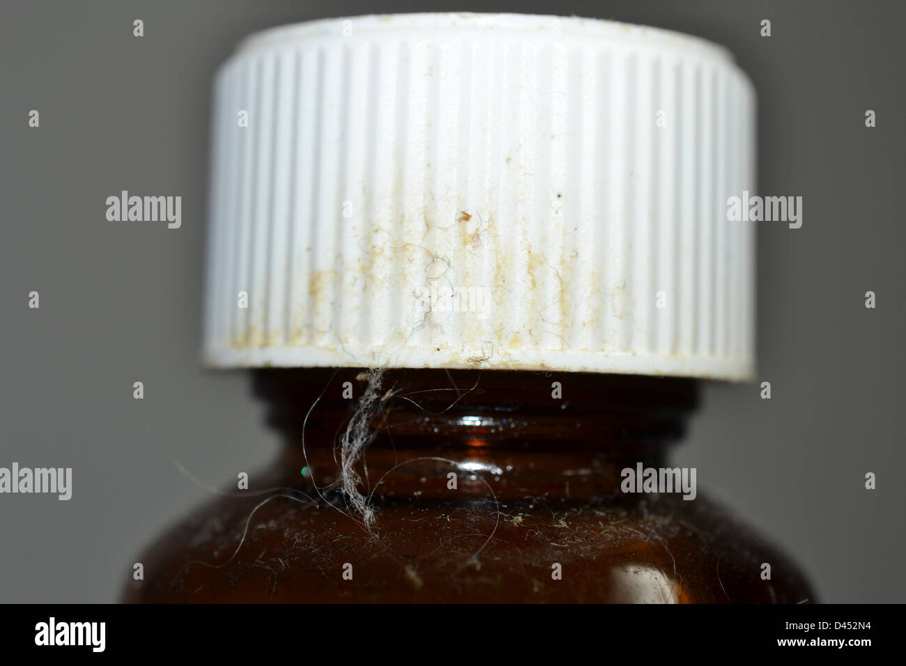 Old dirty dusty hairy medicine bottle with safety cap Stock Photo