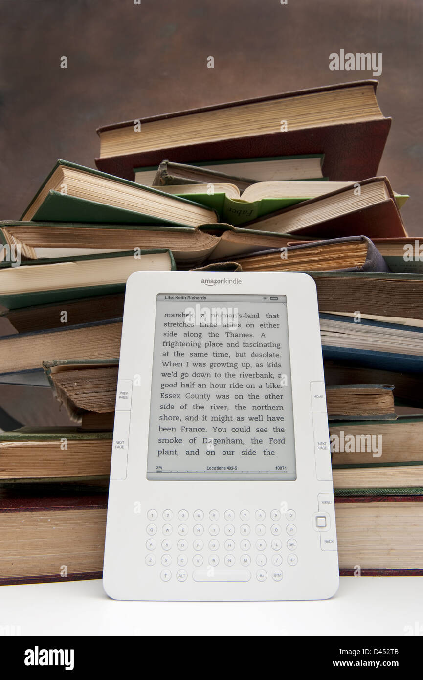 A pile or stack of old books with an Amazon Kindle reader Stock Photo