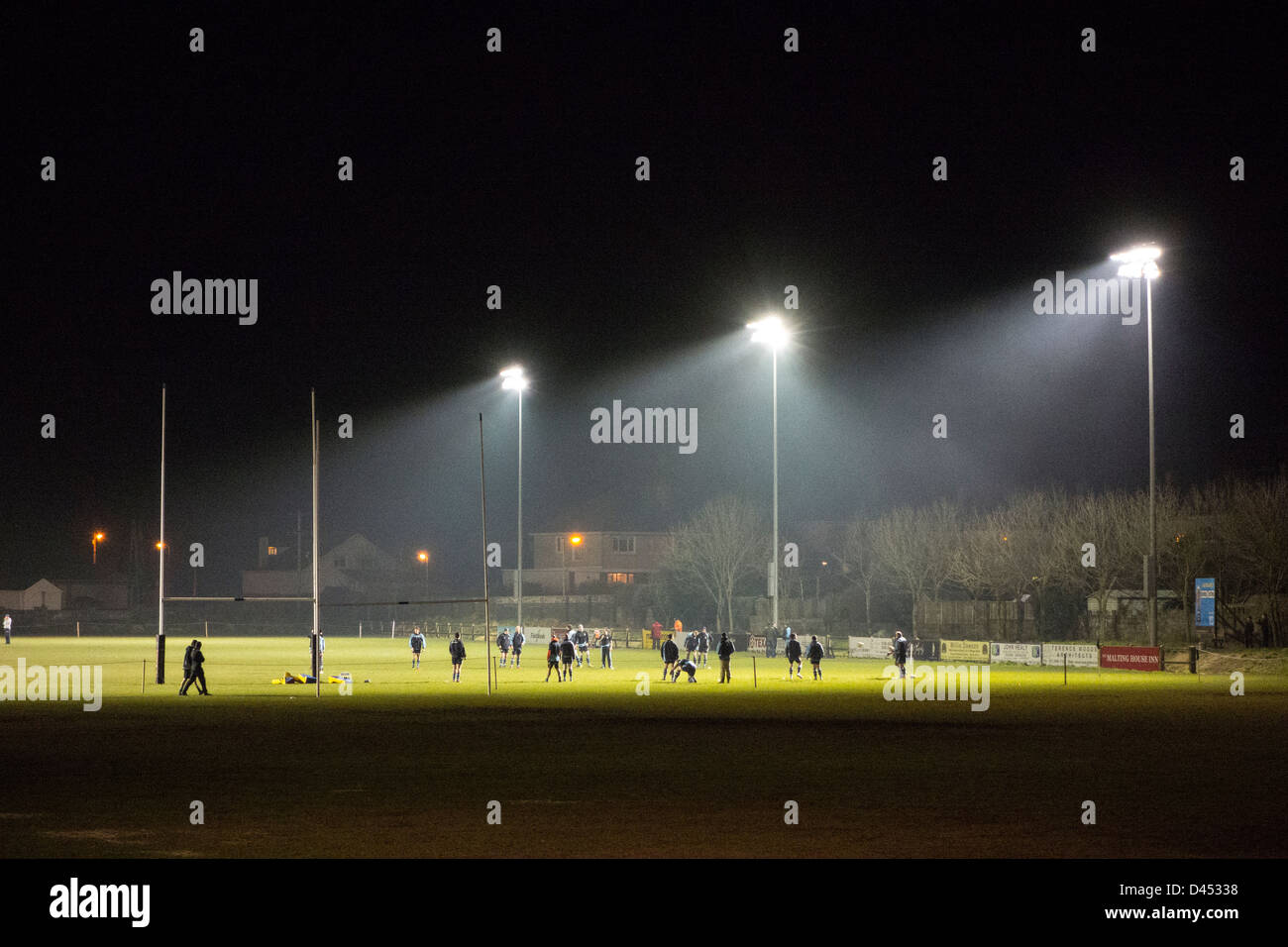 Rugby players exercising on the pitch at night, illuminated by floodlights - near Dublin, Ireland Stock Photo